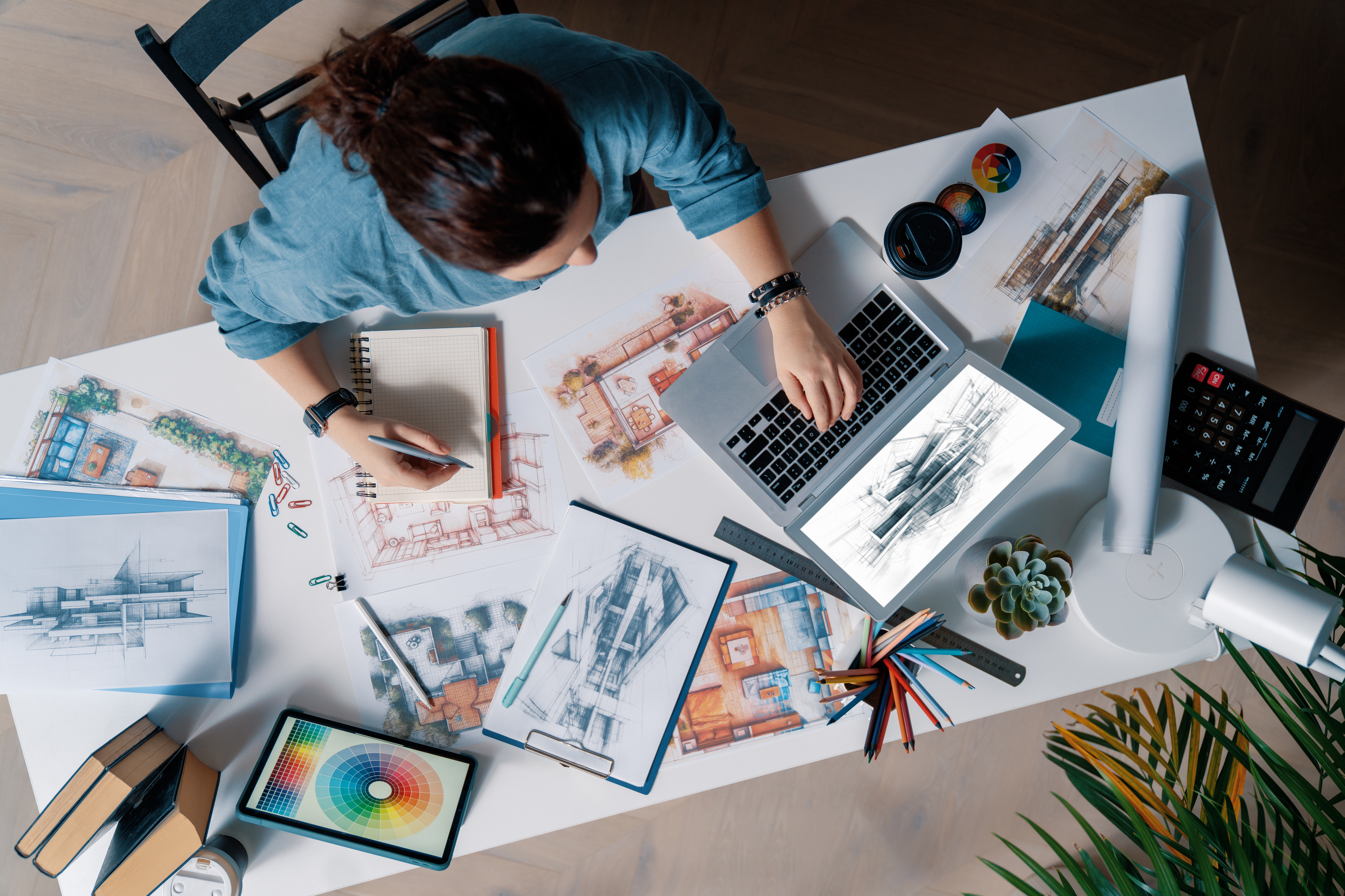 Equipo creativo trabajando en una mesa con bocetos y ordenadores, brainstorming para potenciar una marca en un estudio creativo de branding